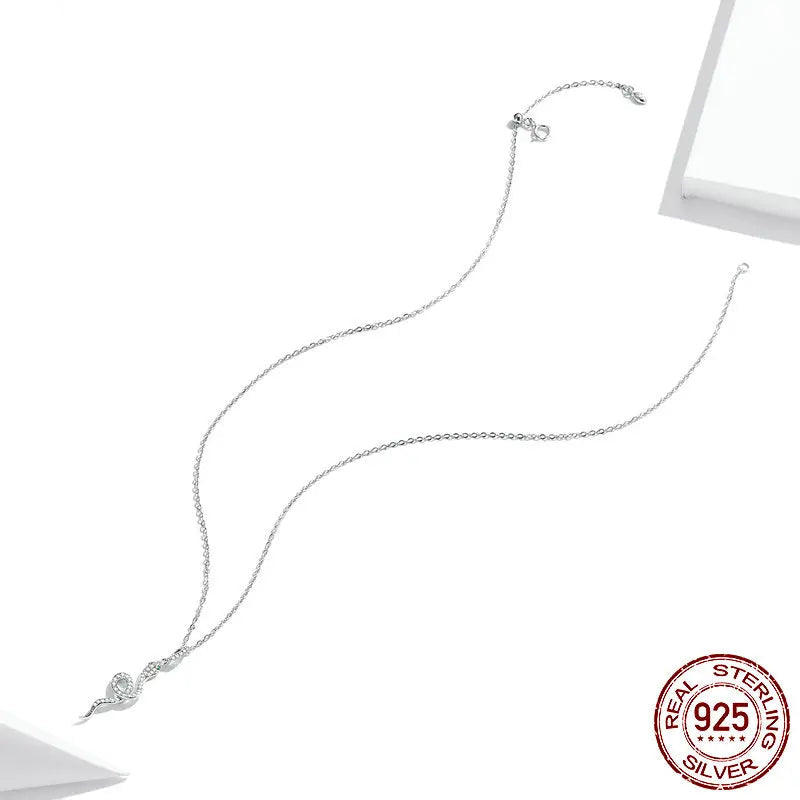 Flat lay of 925 sterling silver snake pendant necklace with pavé CZ and adjustable link chain, full-length view on white backdrop with 925 stamp — OmniVivo