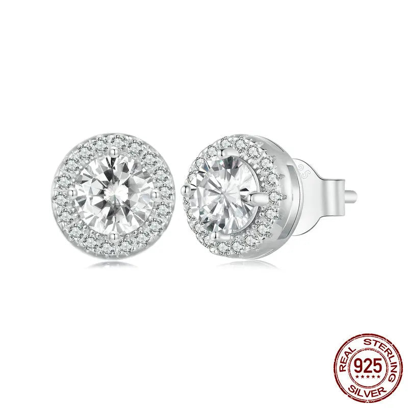 A sparkling pair of Serena Halo CZ Stud Earrings in 925 sterling silver, featuring a brilliant central cubic zirconia stone encircled by a micro-pavé halo, showcasing their celestial elegance and radiant design.
