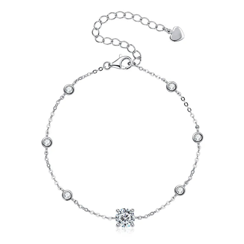 925 sterling silver moissanite bracelet with 6.5 mm round center and 2.5 mm bezel-set accents, adjustable extender chain with heart tag on a white background — OmniVivo