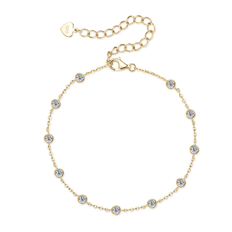 Gold-tone 925 sterling silver moissanite station bracelet with multiple 2.5 mm bezel-set stones and an adjustable extender chain with heart tag on a white background — OmniVivo