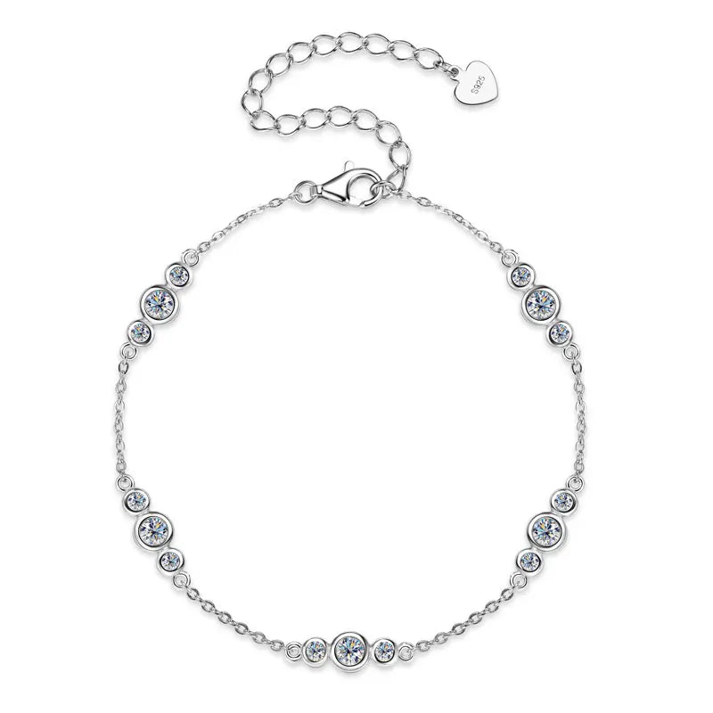 925 sterling silver moissanite station bracelet with graded bezel-set stones and adjustable extender with heart tag on a white background — OmniVivo