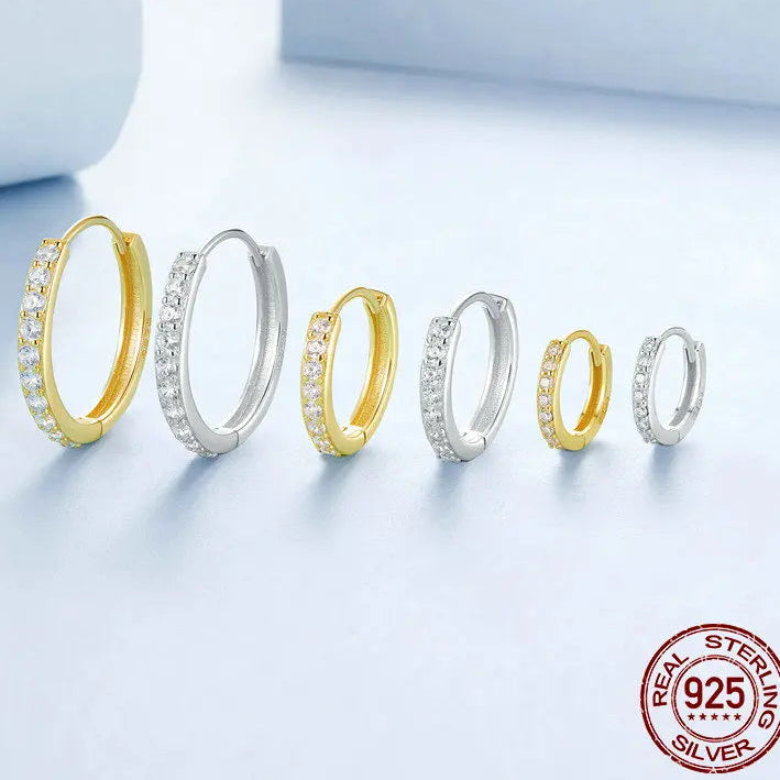 OmniVivo multi-size set of CZ huggie hoop earrings in gold-plated and silver 925 sterling silver, pavé stones, displayed on a light background with a “Real Sterling Silver 925” stamp.