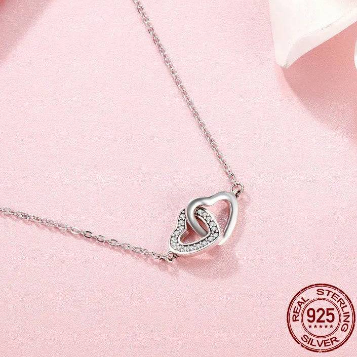 925 sterling silver connected heart pendant necklace with zircon stones on a soft pink background, adjustable link chain, romantic minimalist jewelry — OmniVivo