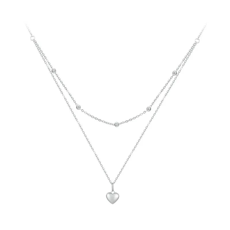 Silver-tone double-layer 925 sterling silver heart pendant necklace with beaded station and link chains on a white background — OmniVivo