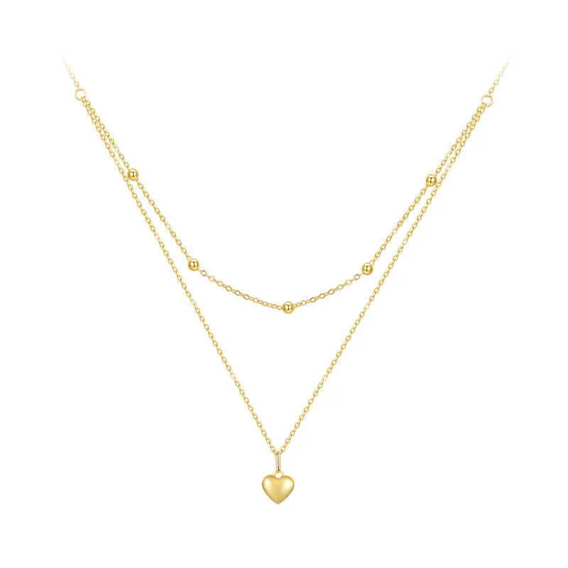 Gold-tone double-layer 925 sterling silver heart pendant necklace with beaded station and link chains on a white background — OmniVivo