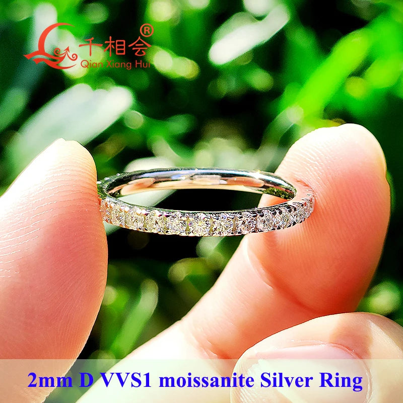 2 mm eternity ring with round D–F VVS1 moissanite in 925 sterling silver, rhodium-plated; between fingers — OmniVivo