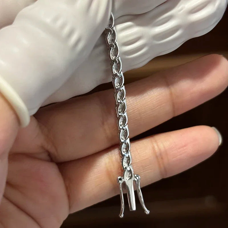 Hand-held detail of moissanite tennis bracelet clasp and links in 925 sterling silver, showing D color VVS1 stones — OmniVivo
