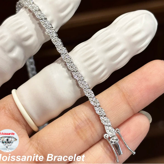 Hand-held close-up of moissanite tennis bracelet in 925 sterling silver with D color VVS1 stones, open clasp detail on white glove background — OmniVivo
