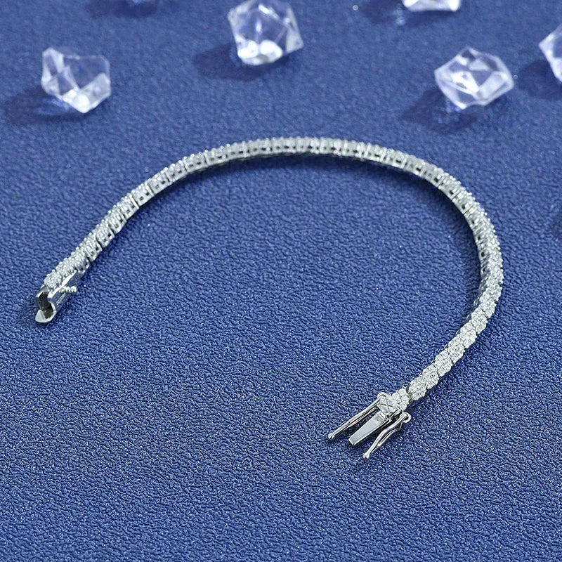Moissanite tennis bracelet in 925 sterling silver with D color VVS1 stones, open clasp view on blue textured background — OmniVivo
