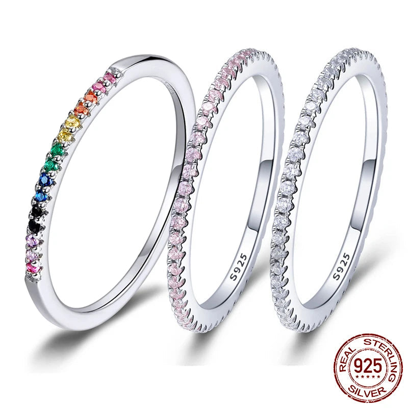Three 925 sterling silver stackable rings with rainbow, pink and white pavé stones, slim polished bands on white background — OmniVivo