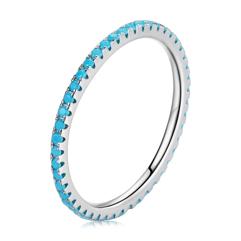 Slim 925 sterling silver eternity ring with blue CZ stones in a pavé setting, polished finish, displayed on a white background — OmniVivo