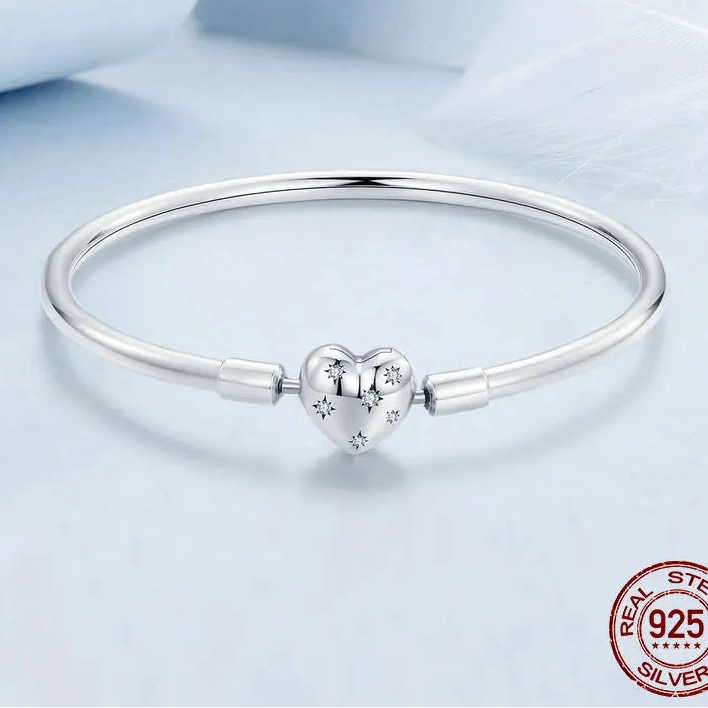 Sleek 925 sterling silver charm bangle with heart clasp, glossy high-polish finish, studio shot on white background — OmniVivo