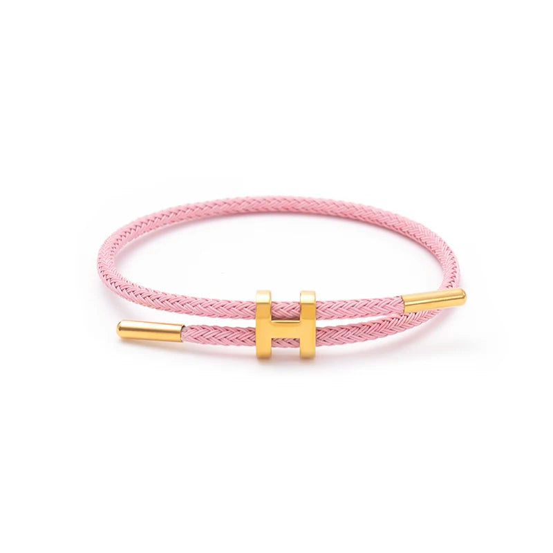 Pink braided rope bracelet with gold-tone stainless steel clasp, adjustable unisex casual bracelet on white background — OmniVivo
