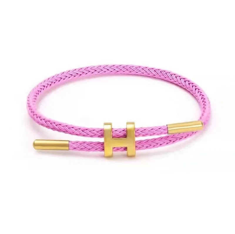 Pink braided rope bracelet with gold-tone stainless steel clasp, adjustable unisex casual bracelet on white background — OmniVivo
