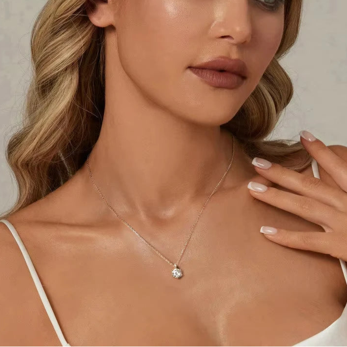 Close-up of a woman wearing a 1 ct D-color VVS1 moissanite solitaire pendant on a 925 sterling silver O-chain