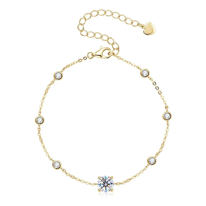 Gold-tone 925 sterling silver moissanite bracelet with 6.5 mm center stone and multiple 2.5 mm bezel-set stations, adjustable extender chain with heart tag on a white background — OmniVivo