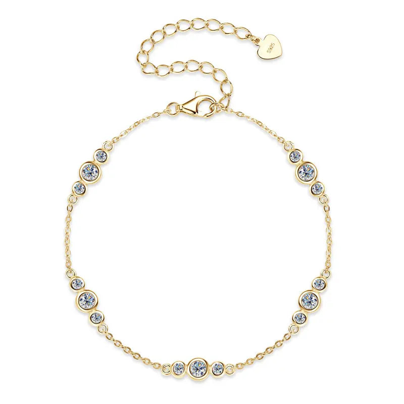 Gold-tone 925 sterling silver moissanite station bracelet with graduated bezel-set stones and an adjustable extender chain with heart tag on a white background — OmniVivo