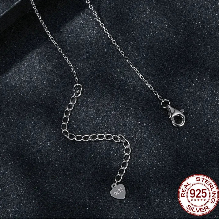 Close-up of 925 sterling silver O-chain necklace with lobster clasp, 5 cm extender, and heart logo tag on a dark background — OmniVivo