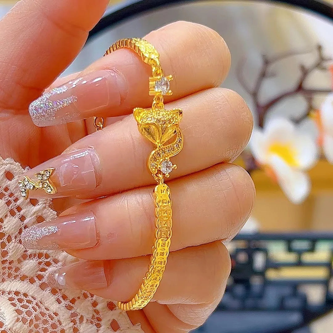 24K (9999) pure gold fox bracelet with chain links and small zircon accents — handheld close-up.