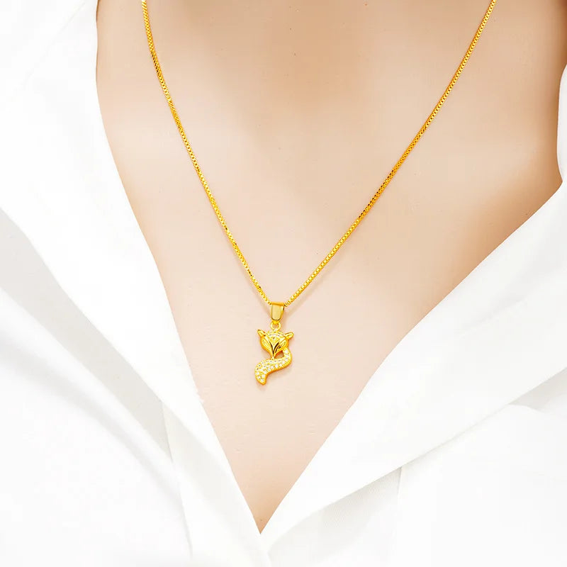 24K (9999) pure gold fox pendant necklace on a model wearing a white blouse — close-up.