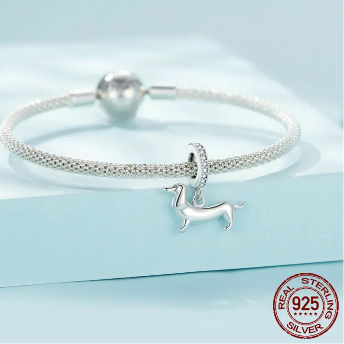 925 silver bracelet with dachshund dog charm bead on light blue.