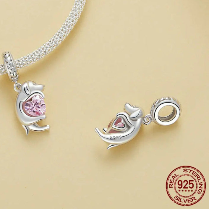 925 sterling silver dog charm bead with pink heart zircon detail on a beige background.