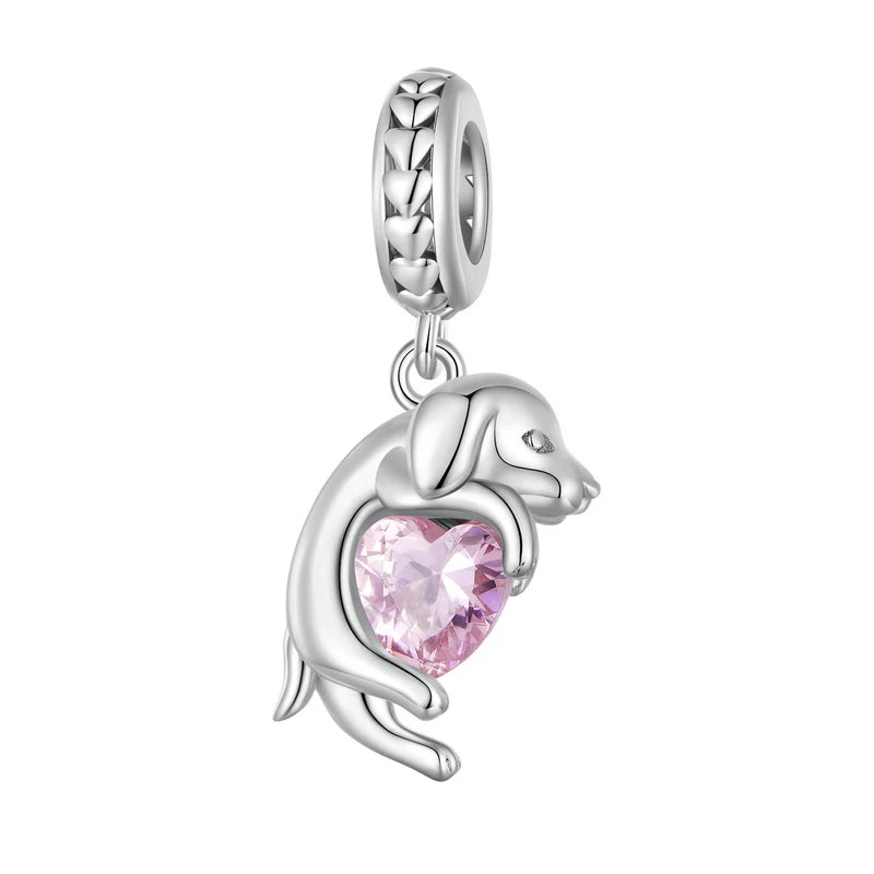 925 sterling silver dog charm bead hugging a pink heart zircon, photographed on a white background.