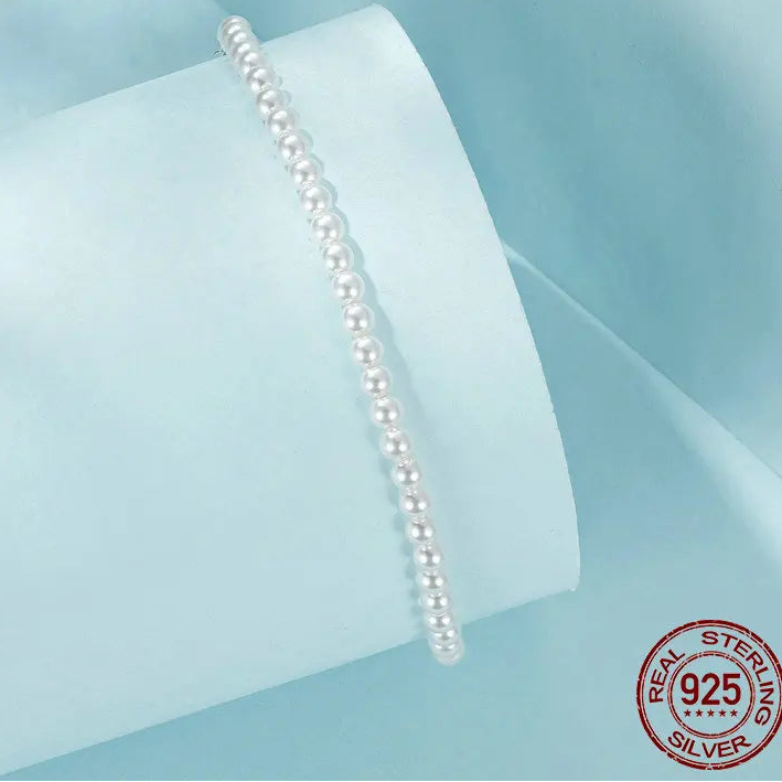 Shell pearl beaded bracelet in 925 sterling silver with adjustable extender on light blue background — OmniVivo
