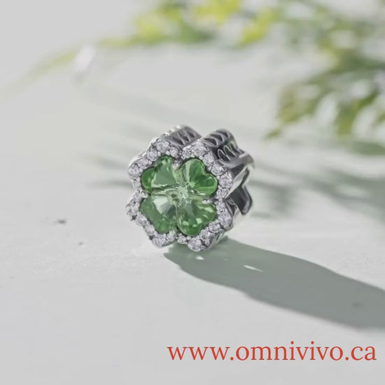 Close-up video of Clover Tree of Life charm in 925 sterling silver with green zircon centerpiece, displayed on light surface with natural background — OmniVivo