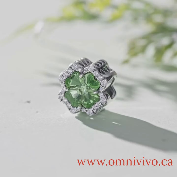 Close-up video of Clover Tree of Life charm in 925 sterling silver with green zircon centerpiece, displayed on light surface with natural background — OmniVivo