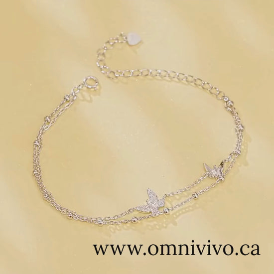 Double-layer butterfly bracelet in 925 sterling silver with pavé CZ, adjustable extender on soft gold backdrop — OmniVivo