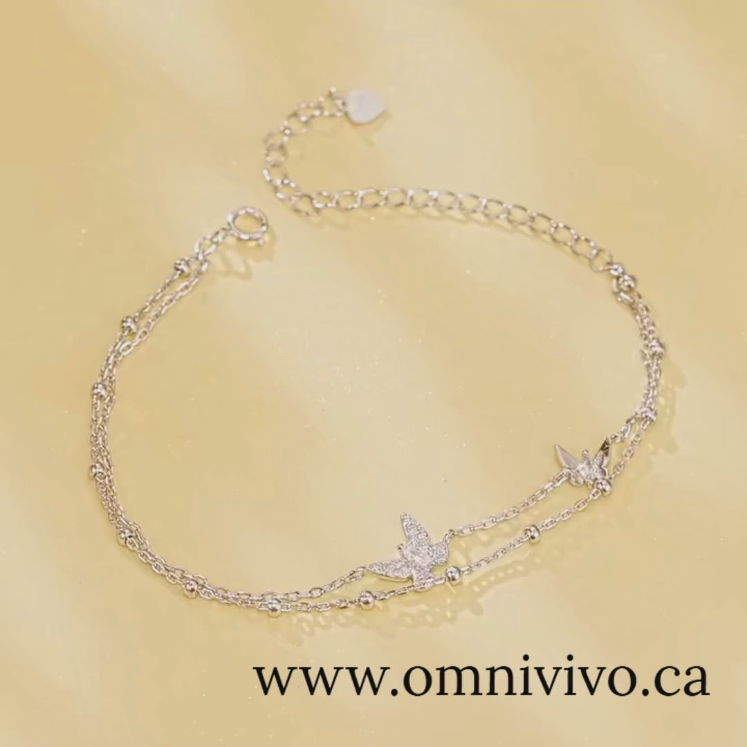Double-layer butterfly bracelet in 925 sterling silver with pavé CZ, adjustable extender on soft gold backdrop — OmniVivo