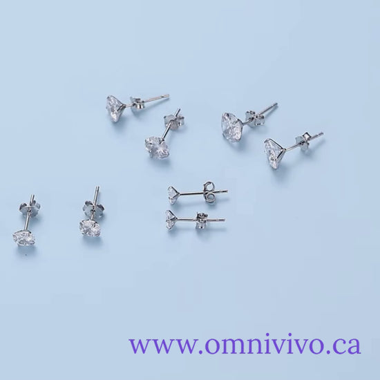 CZ stud earrings in platinum-plated 925 sterling silver, assorted pairs in 4–7mm sizes, displayed on a light blue background — OmniVivo