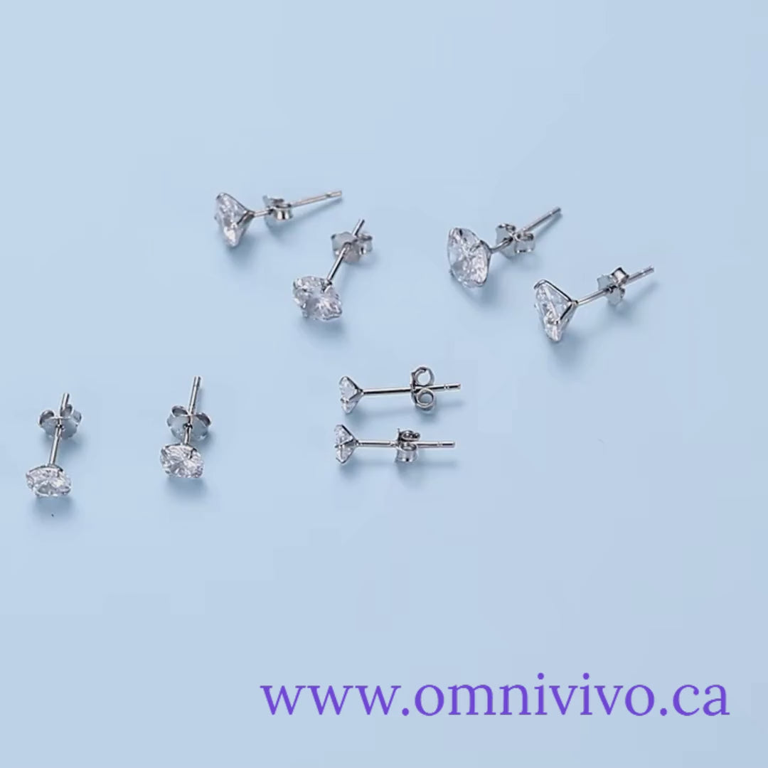 CZ stud earrings in platinum-plated 925 sterling silver, assorted pairs in 4–7mm sizes, displayed on a light blue background — OmniVivo