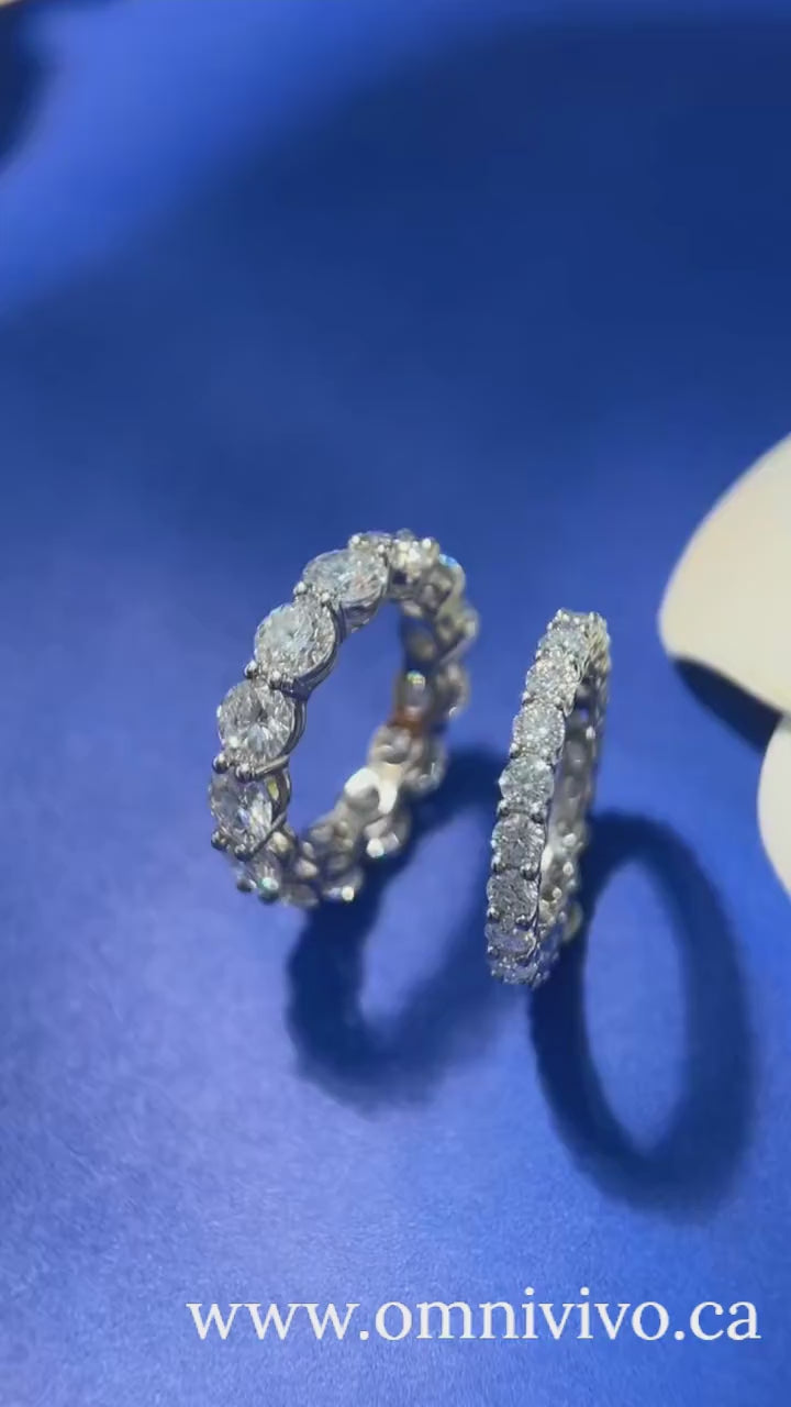 Hero video of a 5 mm D color VVS1 moissanite row ring in solid 925 sterling silver—sparkle movement on blue background.
