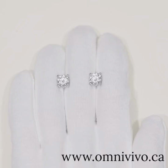 Close-up video of 0.5–1 ct D-Color VVS1 moissanite stud earrings in 925 sterling silver with screw backs, white-gold finish, shown on white glove — OmniVivo