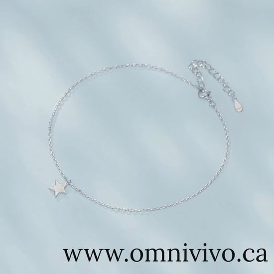 Video of minimalist star anklet in 925 sterling silver with polished adjustable chain, displayed on light blue background — OmniVivo