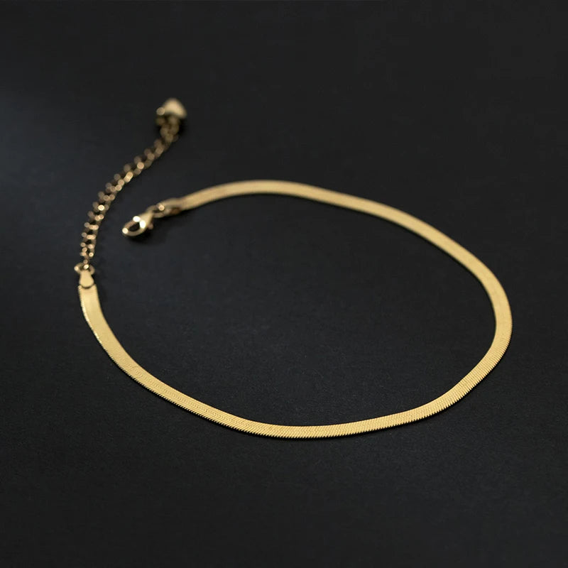 Gold-tone snake chain anklet in 925 sterling silver with adjustable extender on a black background.