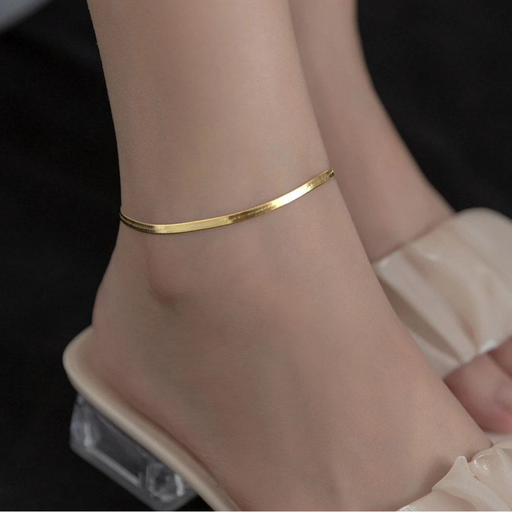 Gold-tone snake chain anklet in 925 sterling silver on a woman’s ankle, minimalist shine